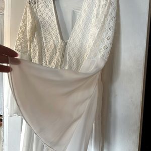 Long lacy dress with plunging neck lines. Long frilly sleeves. Zip side.